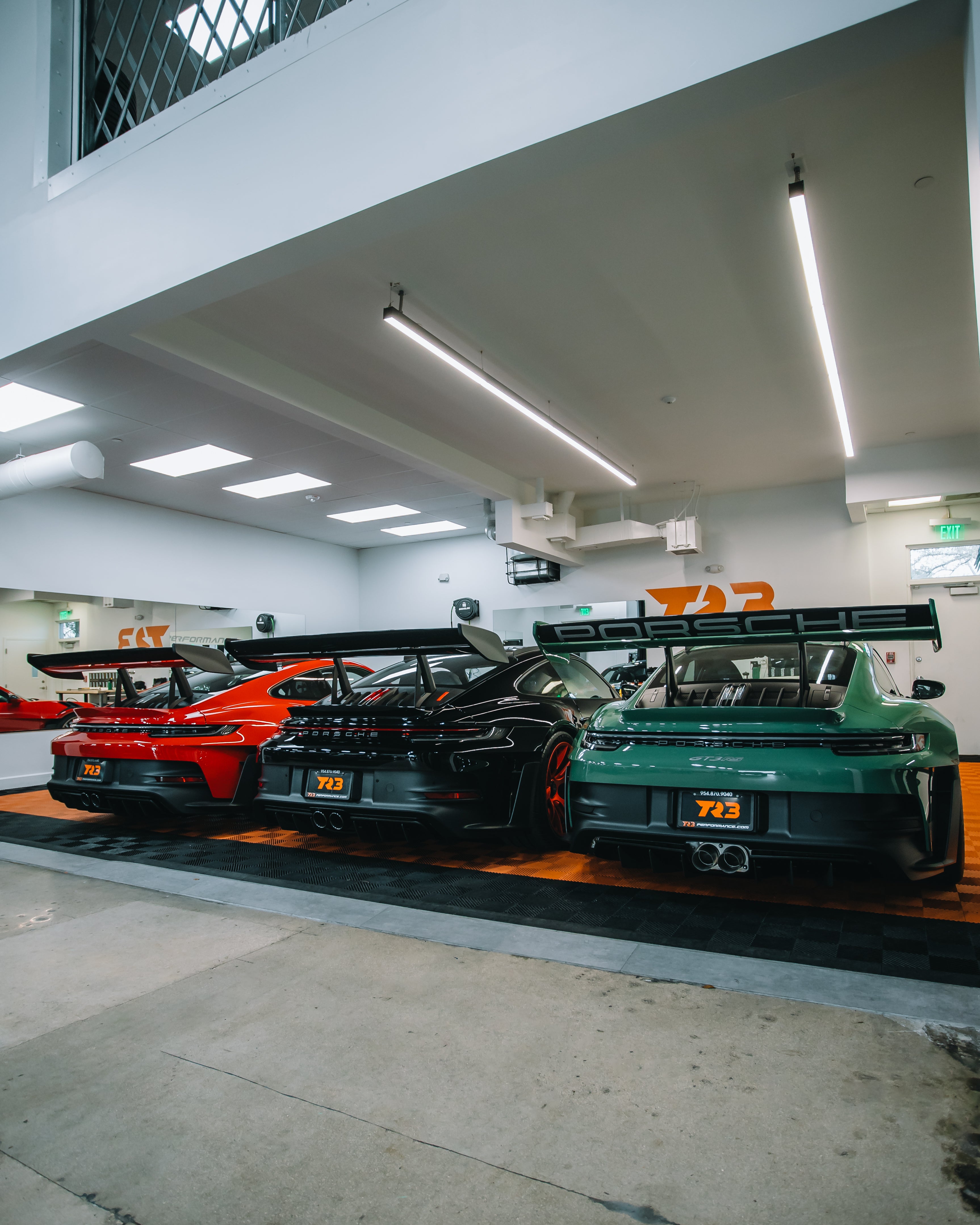 Red Porsche 911 GT3 RS, Black Porsche 911 GT3 RS with Weissach, and PTS Green Porsche 911 GT3 RS in TR3 Performances' PPF Bay in South Florida